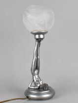 A Resin Art Deco Style Lamp Base in the Form of a Nude Supporting Opaque Globe Shade with Feet,