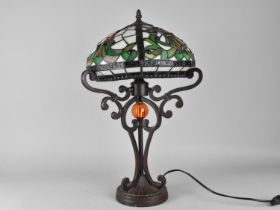 A Tiffany Style Table Lamp on Bronzed Supports, 51cms High