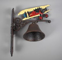 A Cast Metal Wall Hanging Bell with Bi-Plane Motif, 27x33cms High, Plus VAT