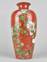 An Oriental Porcelain Vase decorated in Shallow Relief with Blossoming Chrysanthemums on Red Ground,