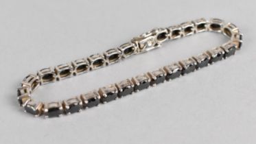 A Silver and Garnet Tennis Bracelet Comprising Oval Cut Stones in Four Claw Mounts