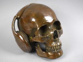 A Cast Bronze Study of a Skull with Headphones