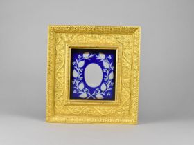 A Gilt Frame of Ornate Stepped Form having Blue Overlaid Glass Panel, 24x25cms