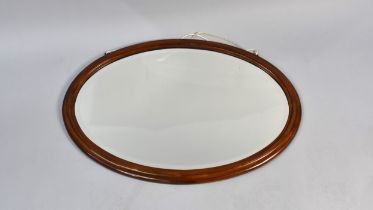 A Mahogany Framed Oval Mirror with Bevelled Glass