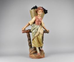 A Large Cold Painted Terracotta Figure of Grape Picker with Basket on Vine Trellis, 54cms High