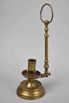 A Brass Candlestick with Suspension Handle, 27cms High
