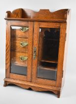 An Edwardian Oak Smokers Cabinet with Glazed Doors to Fitted Interior having Three Drawers,