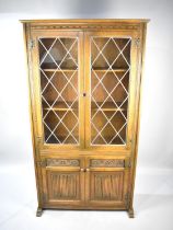 A Mid 20th Century Oak Linen Fold Lead Glazed Bookcase with Cupboard Base, 101cm wide