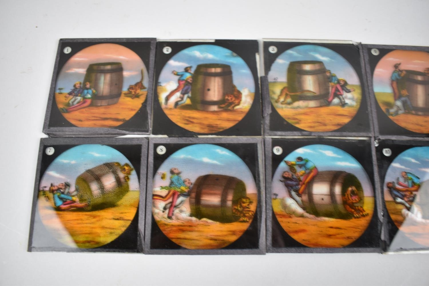 A Collection of 12 Coloured Magic Lantern Slides depicting Two Men Trying to Catch a Tiger in a - Image 2 of 3