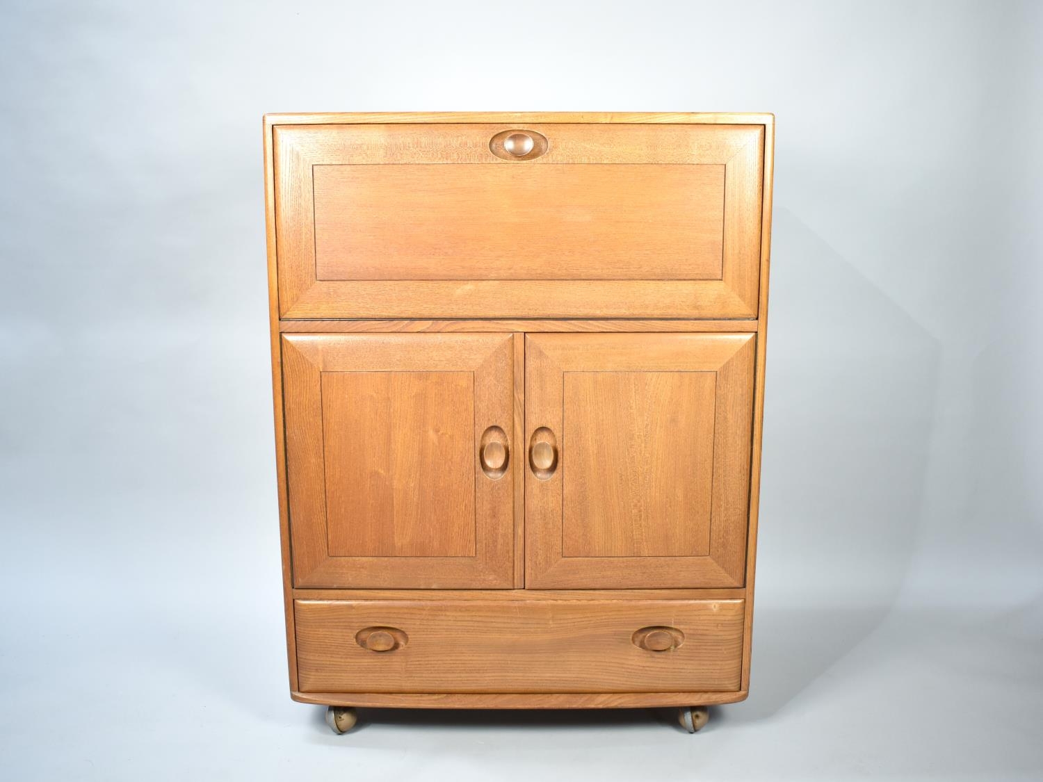 An Ercol Side Cabinet with Pull Down Front, Cupboard Centre, Long Drawer to Base together with Three