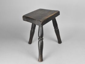 A Rustic Style Three Legged Milking Stool on Turned Supports, 26cms Wide