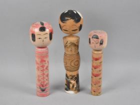 A Graduated Set of Three Painted Wooden Kokeshi Dolls