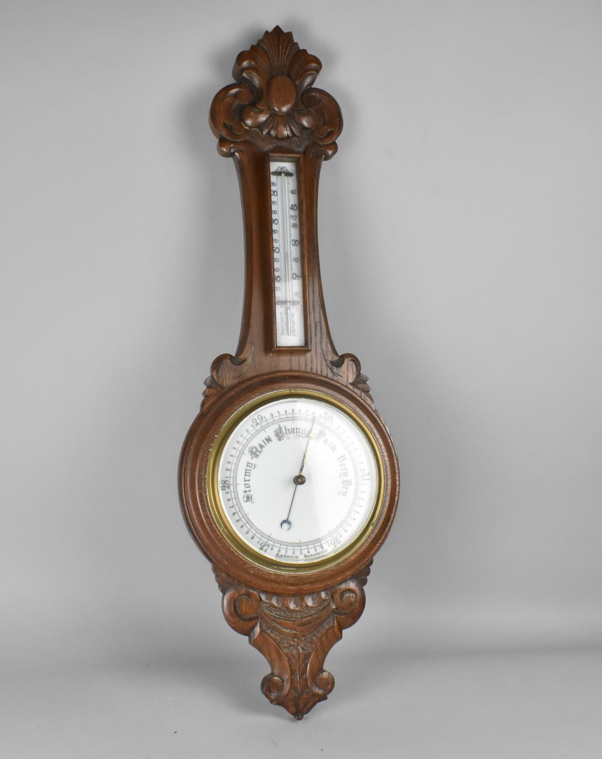 A Late Victorian/Edwardian Carved Oak Onion Topped Wheel Barometer with Thermometer