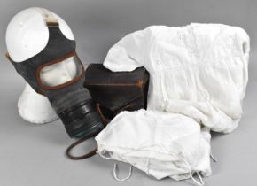 A Leather Cased WWII Gas Mask together with Three Babies Christening Gowns and an Undershirt