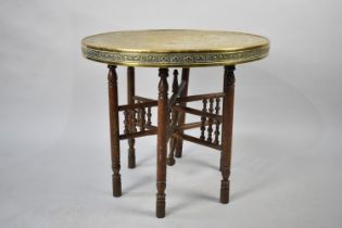 An Indian Brass Benaries Tray Top on Folding Wooden Stand, 60cms Diameter