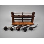 An Edwardian Mahogany Pipe Stand in the Form of a Five Bar Gate together with Four Vintage Pipes,