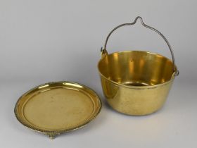 A Vintage Brass Jam Kettle, 27cms Diameter together with a Circular Brass Tray with Three Scrolled