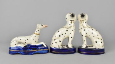 A Pair of Staffordshire Style Studies of Spotted Spaniels Modelled Seated on Cushions Together