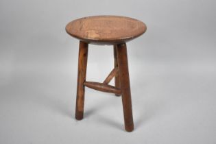 A Small Circular Topped Milking Stool with Tripod or 'Cricket' Turned Supports, 20cms Diameter and