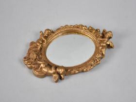 A Modern Moulded Gilt Framed Oval Wall hanging Mirror with Cherub Finial, 23cms High