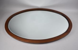 An Edwardian Oval Mahogany Framed Wall Mirror, 82x56cms