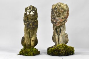 A Near Pair of Weathered Cast Composite Stone Garden Lions
