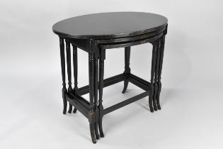 A 19th Century Nest of Three Ebonised Tables With Oval Tops Over Turned Legs United By Stretchers,