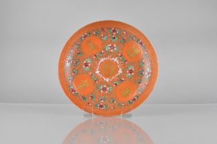 A Chinese Qing Dynasty Porcelain Plate Decorated in the Famille Rose Palette on an Orange Ground