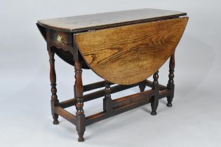 A 19th Century Oak Gate Leg Drop Leaf Table with Oval Top and Turned Supports, 107cms Wide