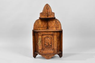 A Small Edwardian Carved Oak Wall Hanging Corner Cabinet with Warrior Mask Decoration to Panelled