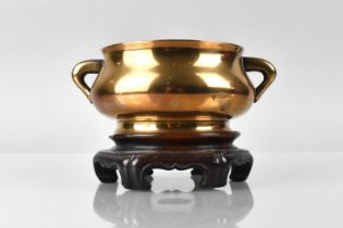 A Chinese Qing Dynasty Polished Bronze Censer of Compressed Bombe Form, with Flaring Foot and Rim