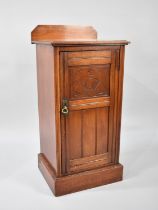 An Edwardian Mahogany Bedside Cabinet with Carved Panelled Door and Galleried Back, 39cms Wide