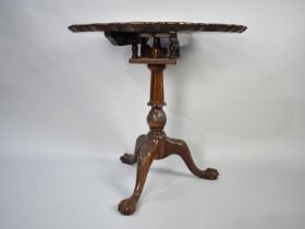 A Reproduction Mahogany Tripod Table with Circular Pie Crust Top, Bird Cage Support and Carved