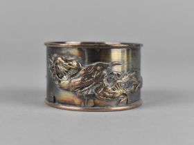 A Chinese White Metal Napkin Ring Decorated in Relief with Dragons Chasing Flaming Pearl, 21g