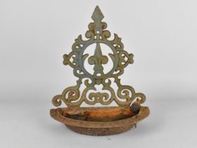 A Cast Metal Wall Mounting Feeder with Ornate Back, 27cm high