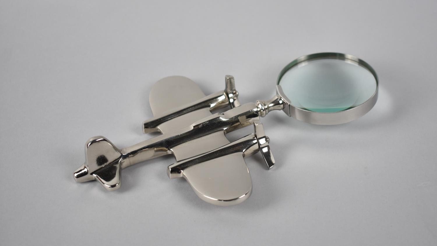 A Reproduction Chrome Metal Novelty Desktop Magnifying Glass in the Form of a Twin Engine Vintage