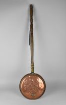 An Ornamental Copper Bed Warming Pan with Turned Wooden Handle