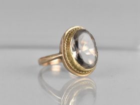 A 9ct Gold and Smokey Quartz Ladies Cocktail Ring, Oval Cut Stone Measuring 12mm by 9.7mm, Collet