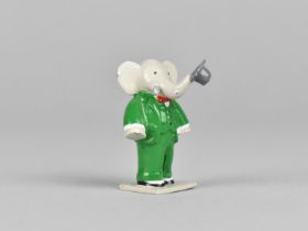 A Cold Painted Miniature Study of Babar the Elephant Modelled Standing with Trunk Carrying Hat,