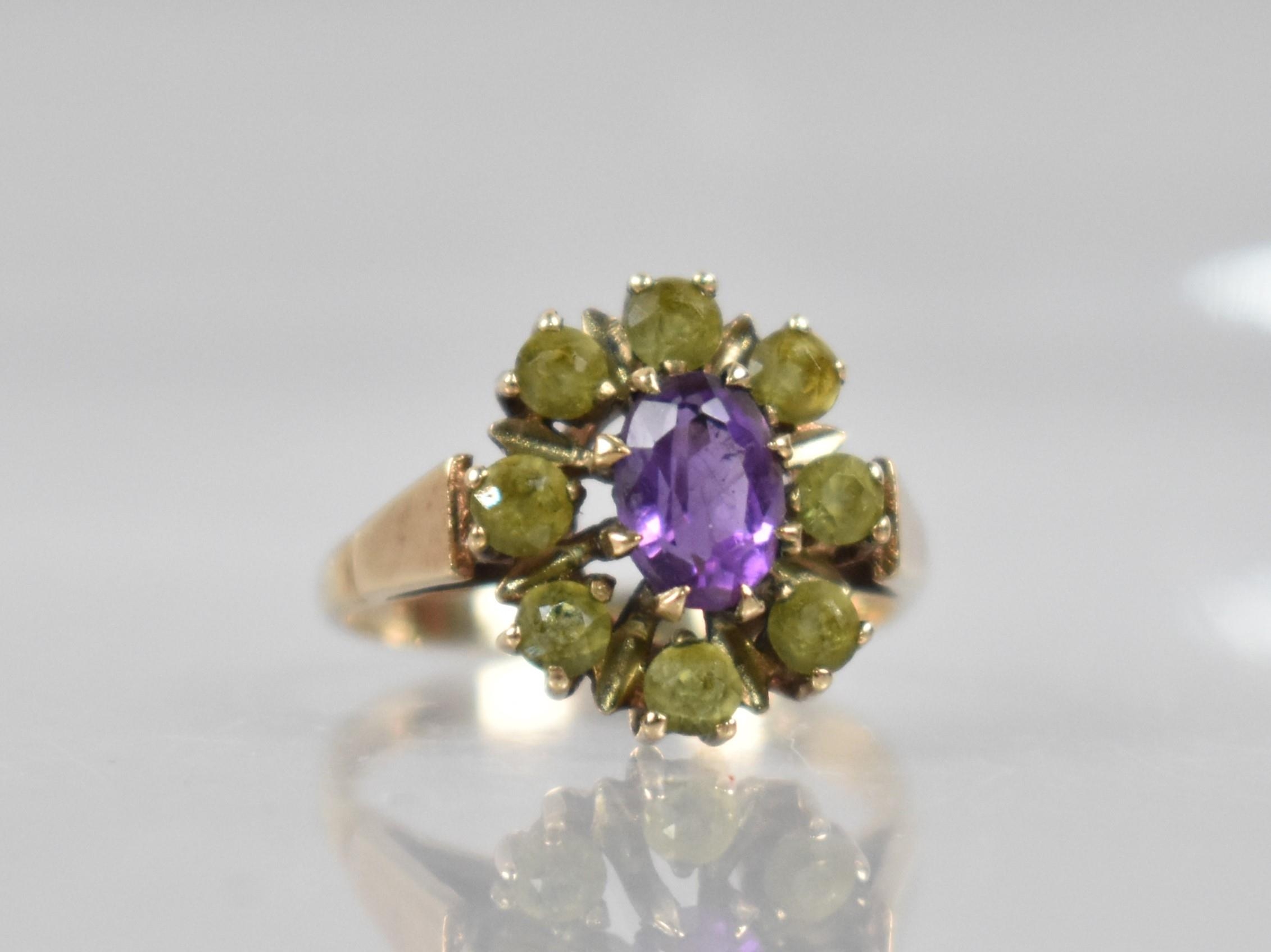 A 9ct Gold, Amethyst and Peridot Ring, Central Oval Cut Amethyst Measuring 7mm by 5.1mm in Eight