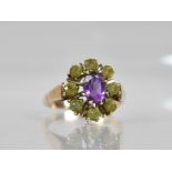 A 9ct Gold, Amethyst and Peridot Ring, Central Oval Cut Amethyst Measuring 7mm by 5.1mm in Eight
