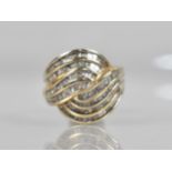 A Large Continental Diamond Mounted Dress Ring comprising Eight Scrolling Bands of Mixed Baguette,
