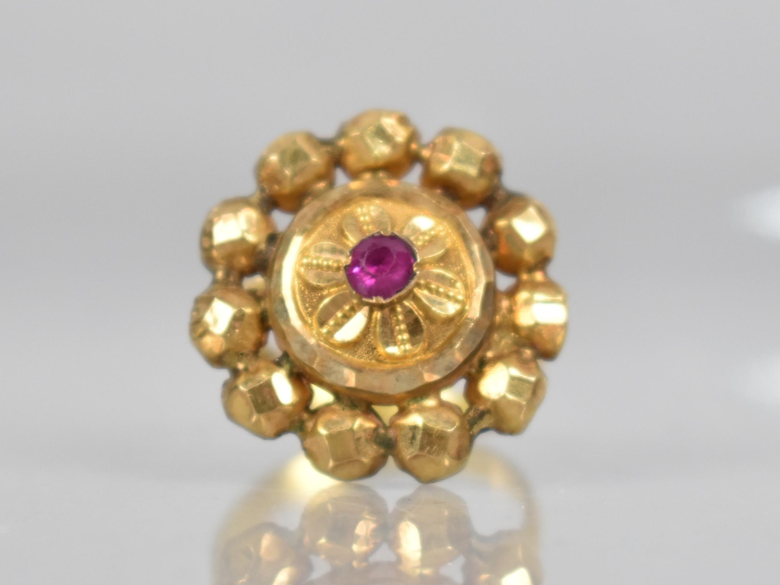 An Indian Gold Coloured Metal and Ruby Ring, Central Ruby Measuring 3.6mm by 3.0mm in a Raised