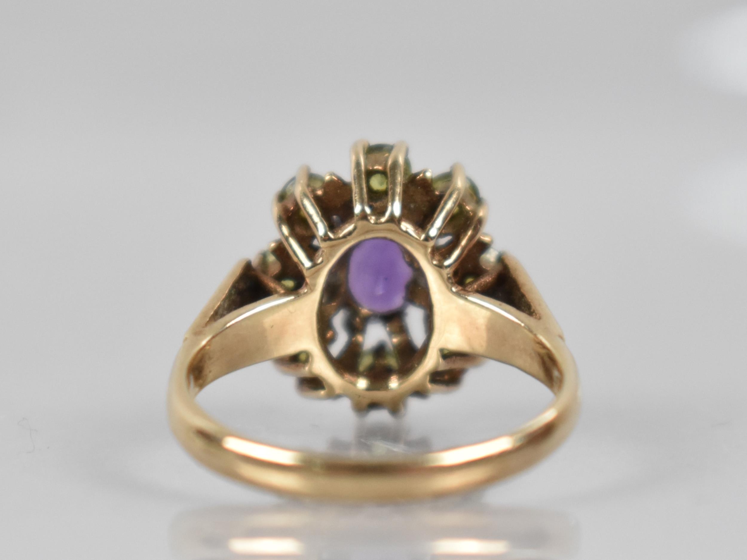 A 9ct Gold, Amethyst and Peridot Ring, Central Oval Cut Amethyst Measuring 7mm by 5.1mm in Eight - Image 3 of 4