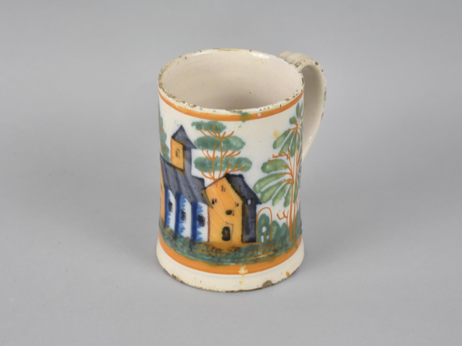 An Early Tin Glazed Mug Decorated with Church in Multicoloured Enamels, 12cms High
