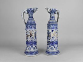 A Pair of German Salt Glazed Mask Head Ewers with Armorial Decoration in Relief, 35cms High