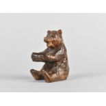 A Black Forest Carved Wooden Bear, Modelled Seated, 6cms High