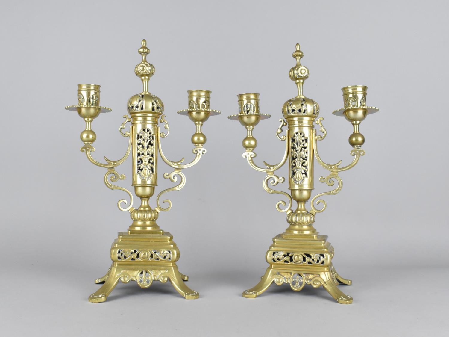 A Pair of Ornate Brass Three Branch Candelabra Garnitures with Pierced Supports Surmounted by