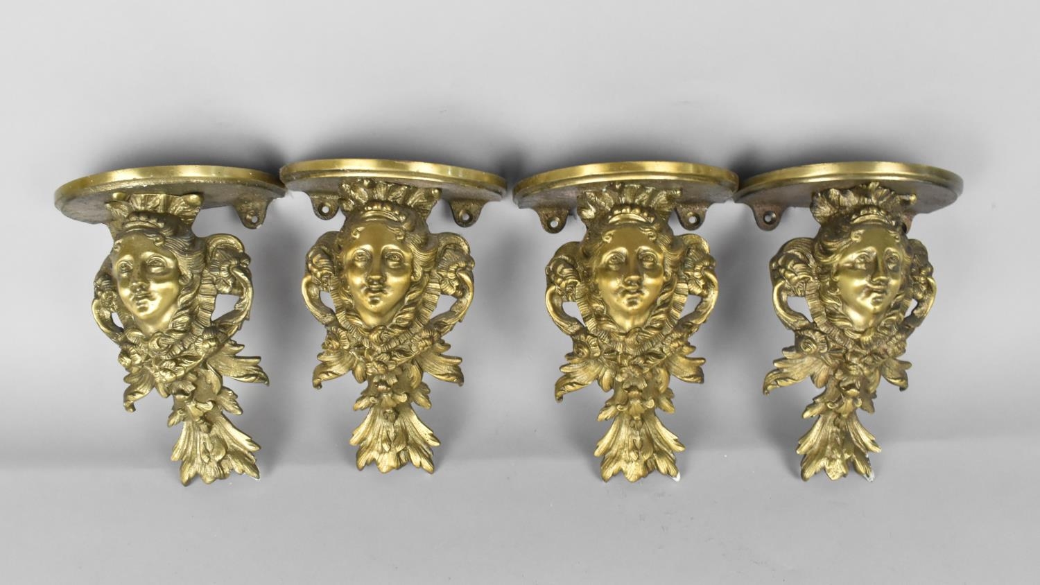 A Set of Four Cast Brass Wall Sconces Modelled with Maidens Head Amongst Foliage and Acanthus