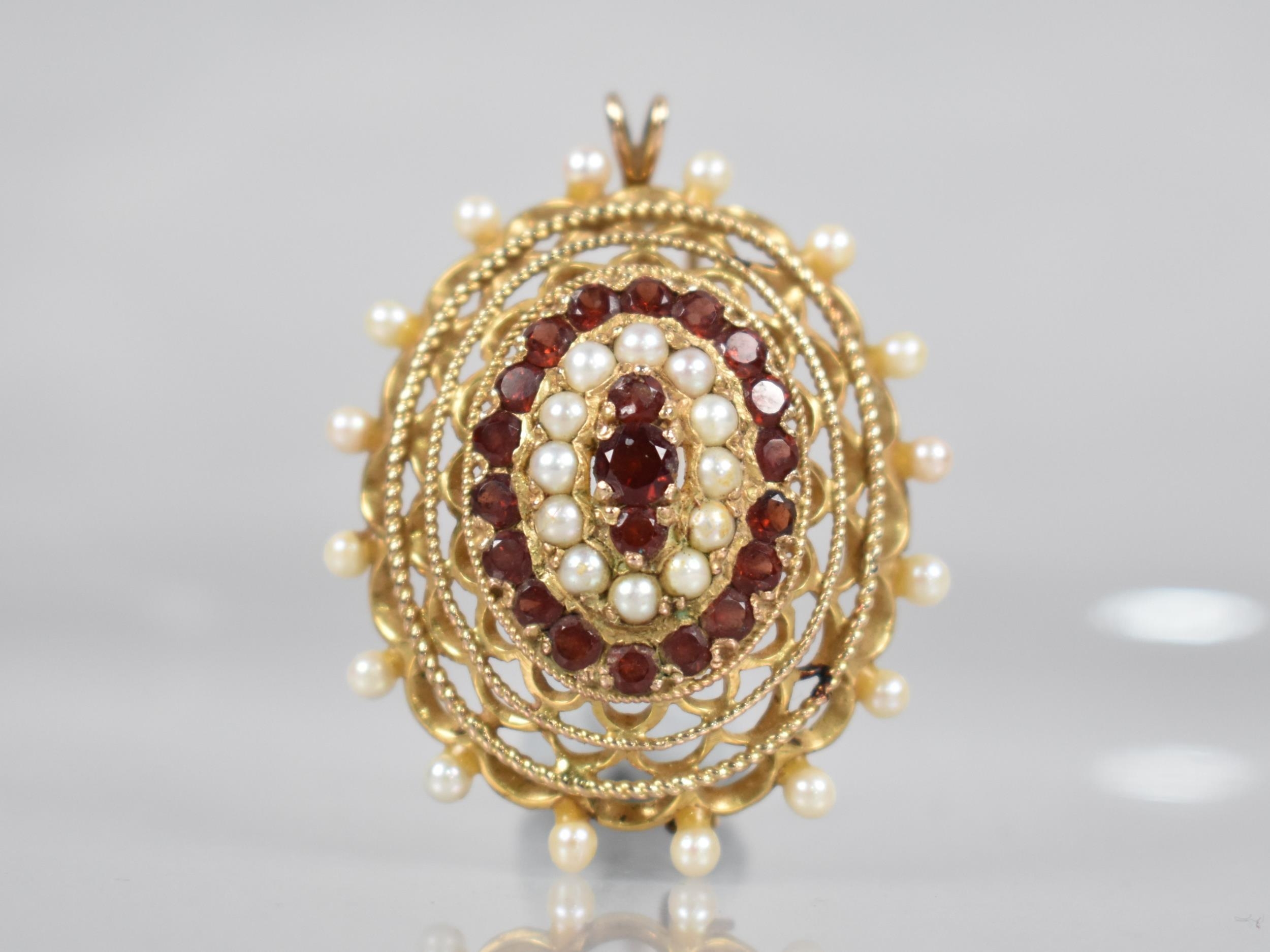 A 9ct Gold, Garnet and Pearl Brooch/Pendant of Oval Pierced Form by Zeeta, Central Round Cut